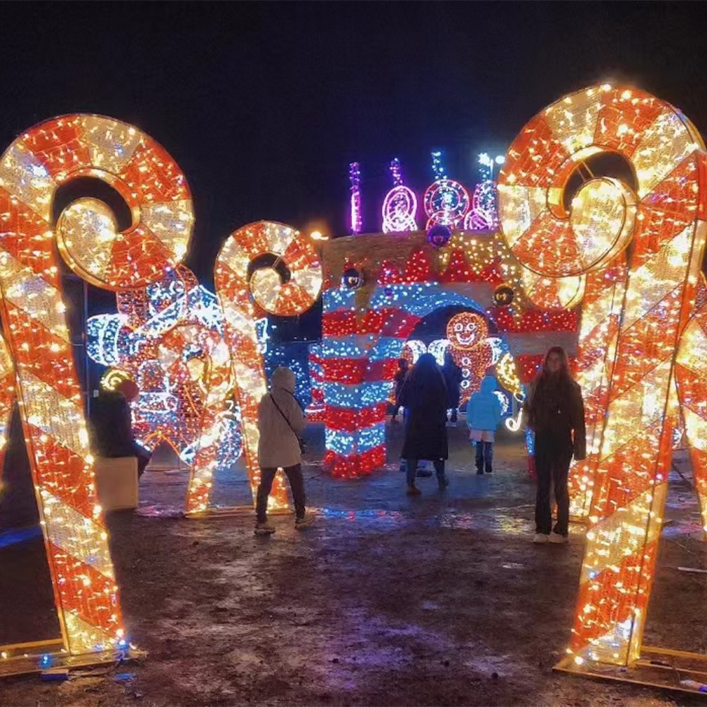 Outdoor holiday display with illuminated candy cane decorations and a lighted backdrop