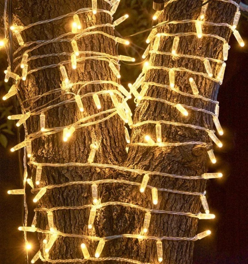 Warm white IP65 LED string lights closely wrapped around outdoor tree trunks
