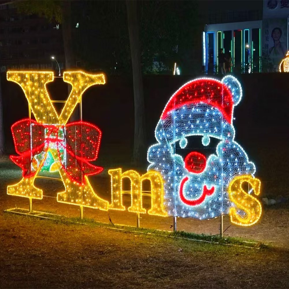 Illuminated Xmas lettering with a bow and a Santa-face motif on a lawn