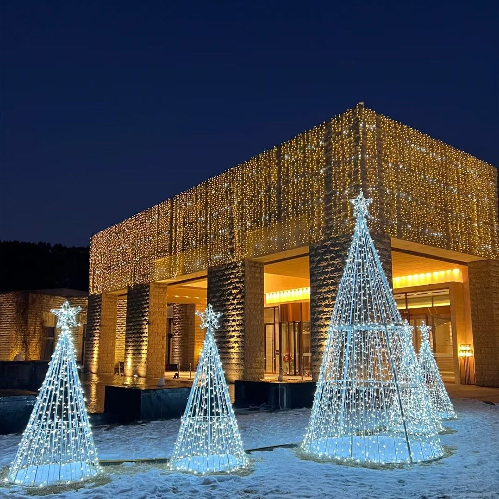 A group of illuminated conical Christmas trees with star toppers in varying heights outside a building entrance