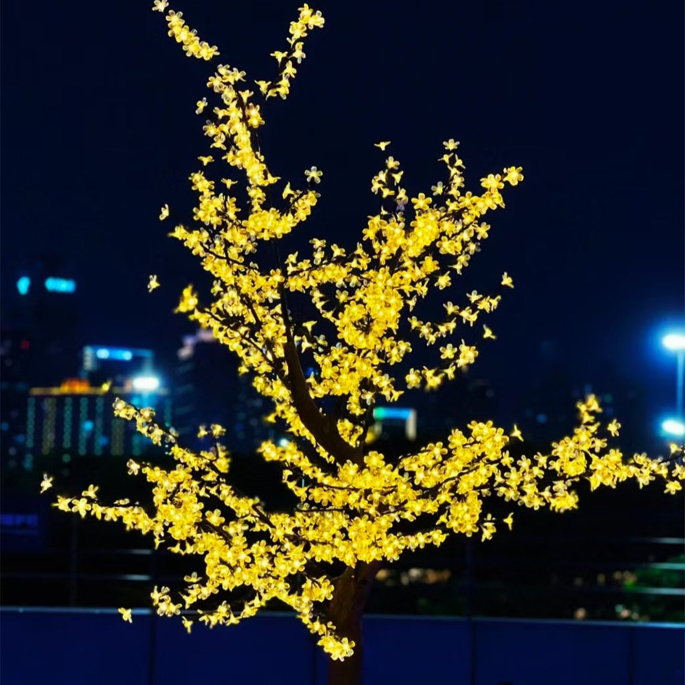 Decorative branching light tree covered with warm-looking illuminated blossom shapes against a night skyline