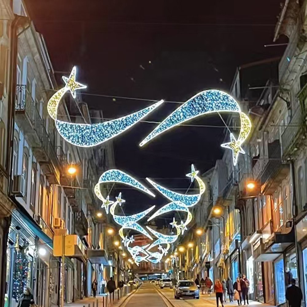 Paired shooting-star ribbon motifs with blue-white tails suspended across a commercial street