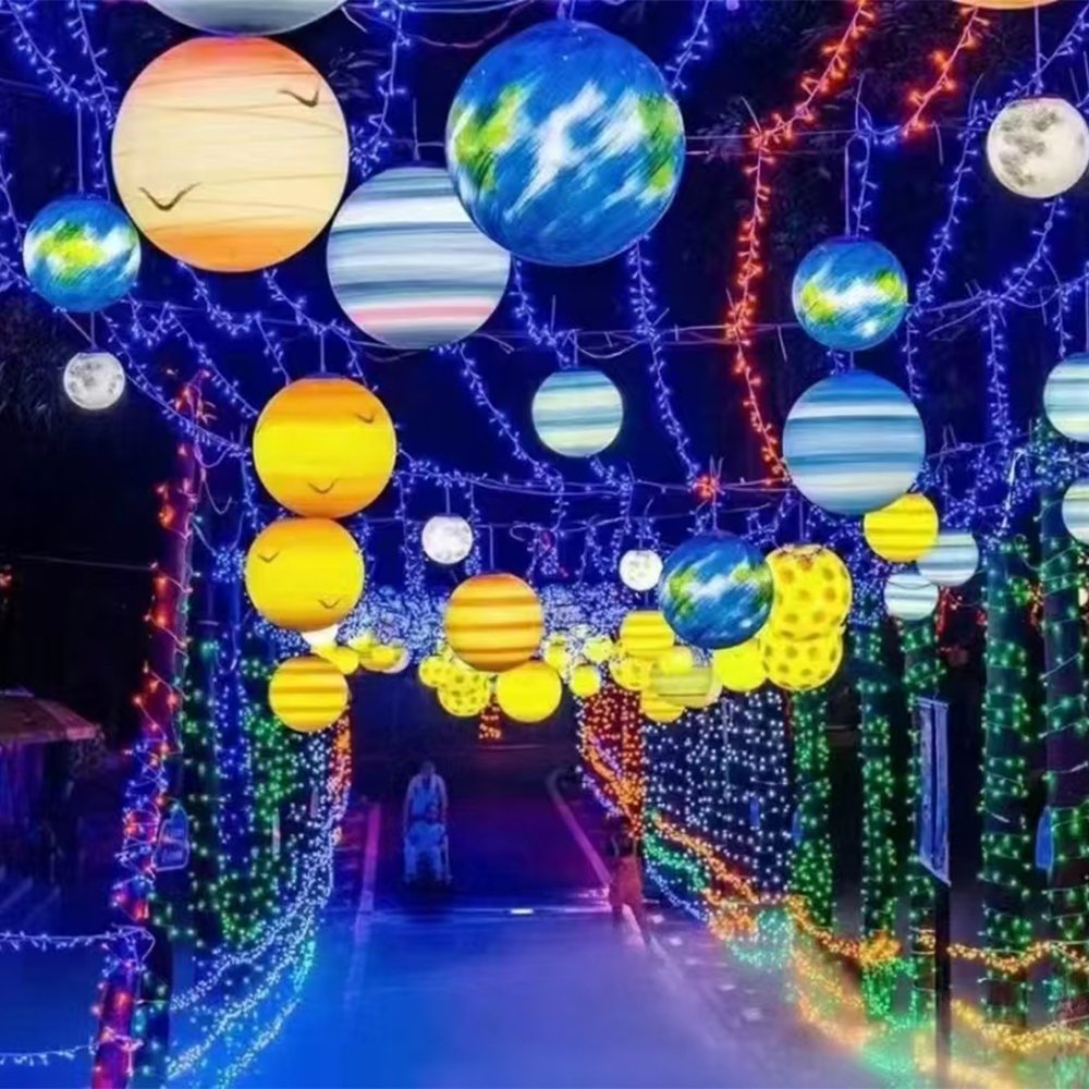 Suspended planet-themed globes with Earth and striped planet appearances above an illuminated event walkway