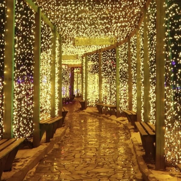 Warm white curtain lights along a covered stone walkway with timber posts and benches