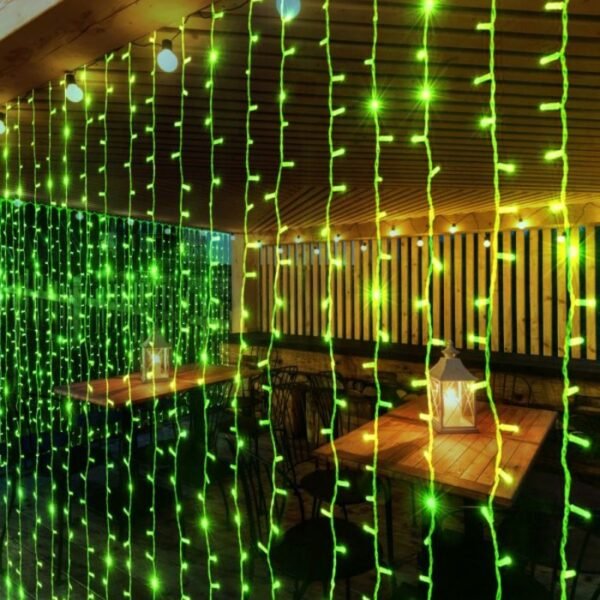 Green vertical curtain lights screening tables and chairs beneath a timber veranda roof