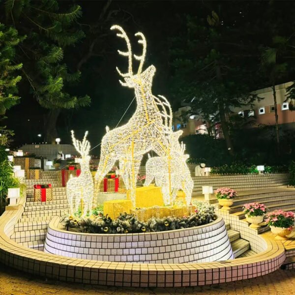 Illuminated antlered deer group in graduated sizes arranged above a circular landscape planter