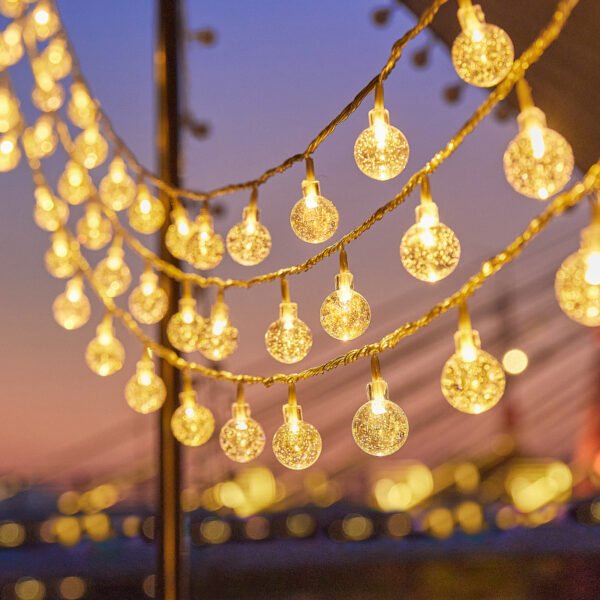 Rows of warm white globe Edison string lights suspended across a dusk event canopy