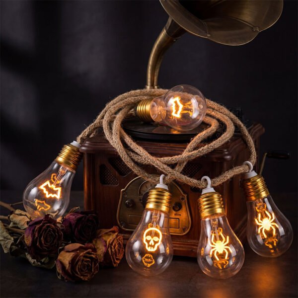 Warm glowing bat skull and spider motifs inside clear Edison-style forms beside a vintage record player and dried flowers