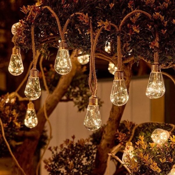 Warm white sparkling pear-shaped decorative lights arranged among branching foliage with textured cord-like lines
