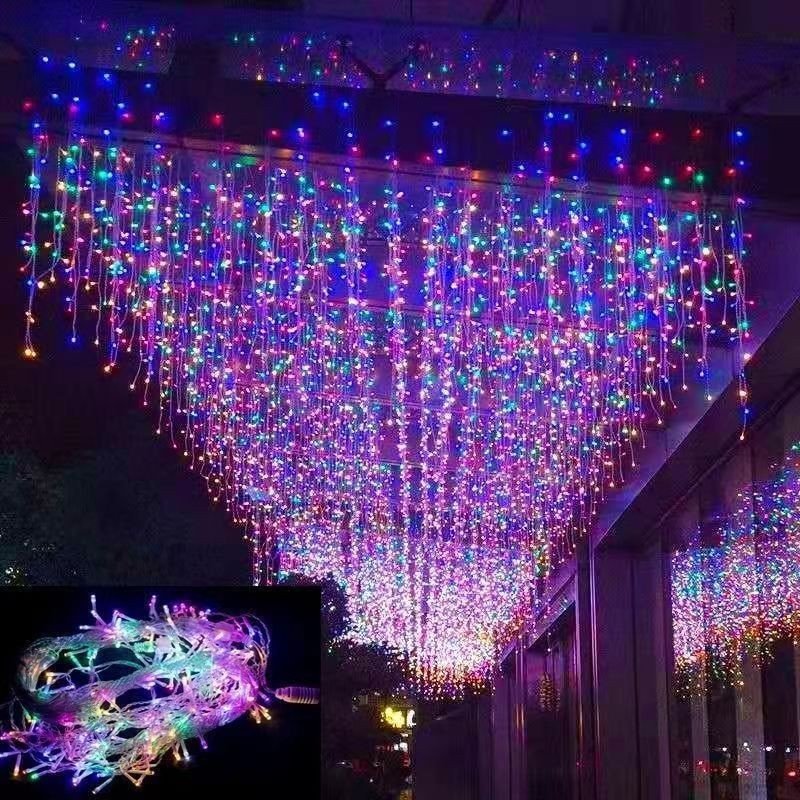 Multicolor hanging icicle light arrangement above an entertainment venue