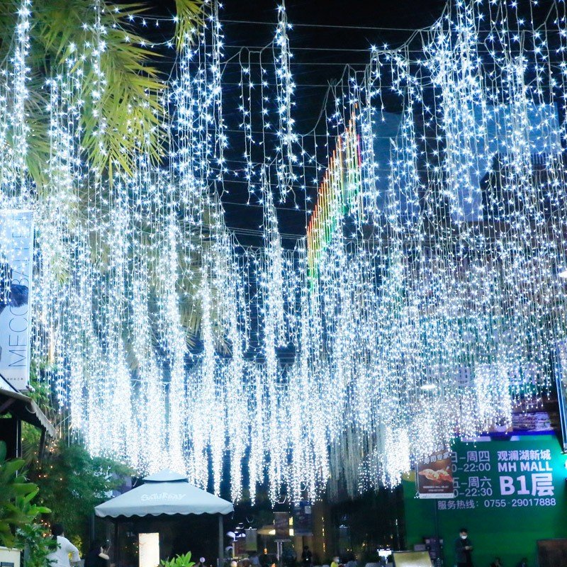 White icicle lighting displayed above a landscaped outdoor arrival area