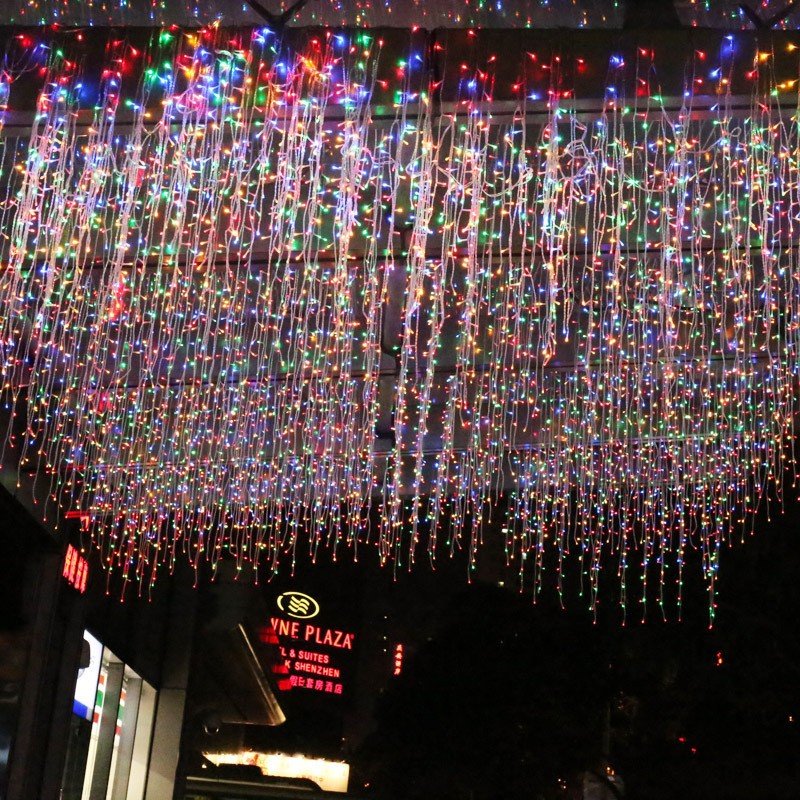 Multicolor icicle strands arranged as a broad overhead decorative composition