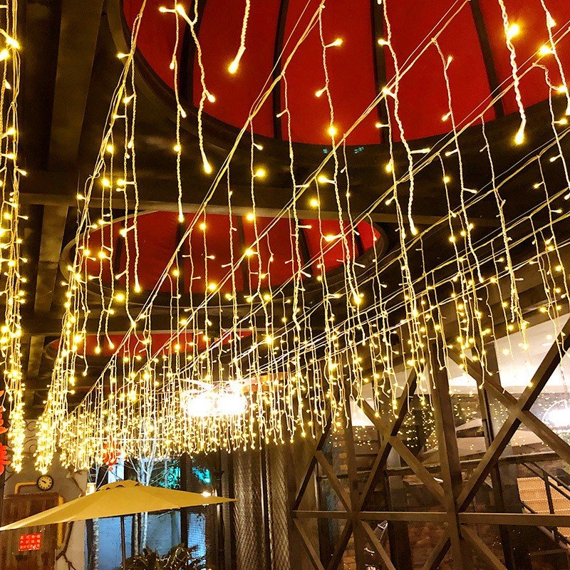 Warm white icicle strands hanging beneath a sheltered roof edge