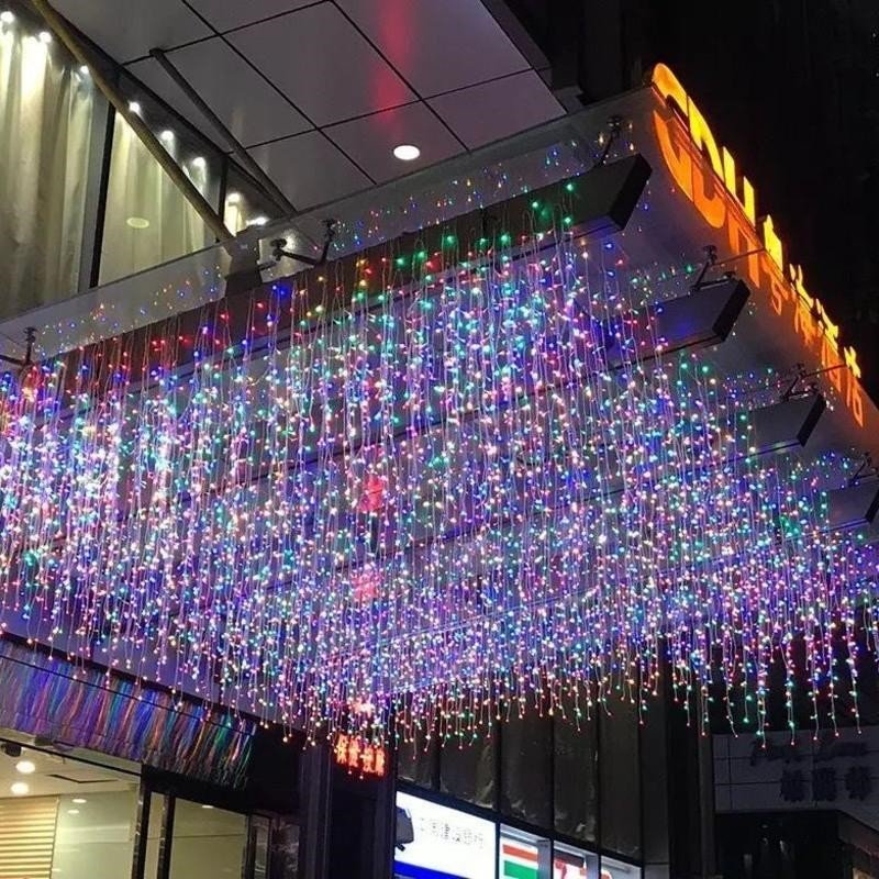 Multicolor hanging icicle light display over a gathering area